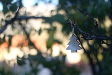 Christmas tree ornament hanging in the garden. Selective focus, beautiful bokeh.