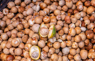 Kadenahalli, Karnataka, India - November 3, 2013: Closeup of heap of freshly peeled betel nuts with one fruit cut open in middle to expose the nut.