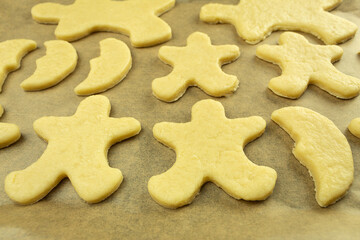 The Christmas gingerbread cookies are laid out on a baking sheet and ready to bake in the oven