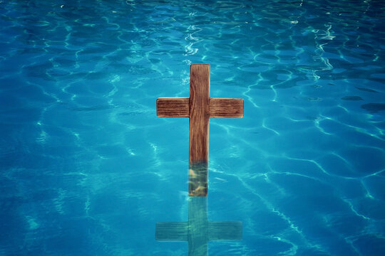 Wooden cross in water for religious ritual known as baptism