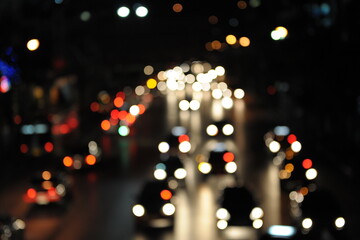 defocused lights of cars on a busy road at night