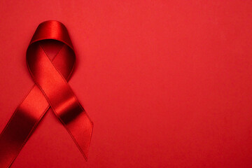Hiv day. Red ribbon symbol in hiv world day on dark red background. Awareness aids and cancer. Aging Health month concept.