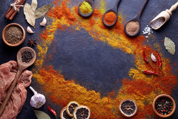 Cutting board with spices and herbs for cooking meat on dark background