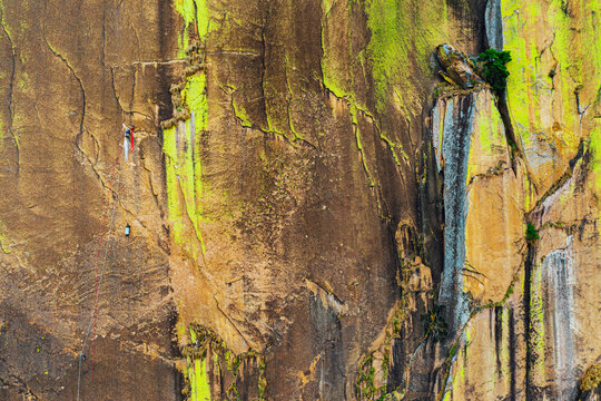 Aerial shot of rock climber on belay hauling haul bag