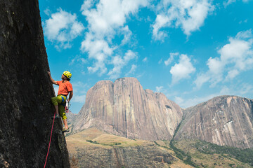 Climber man leading a multipitches route in Chameleon Wall in Tsaranoro Valley