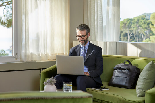 Businessman sitting by the coffee table working on laptop
