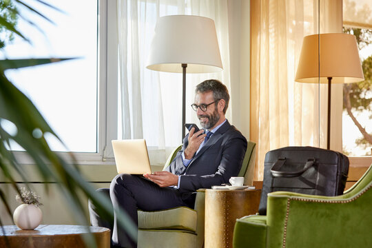Businessman sitting by the coffee table working on laptop