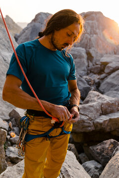 Focused Ethnic Mid Aged Male Climber Doing Rope Knot