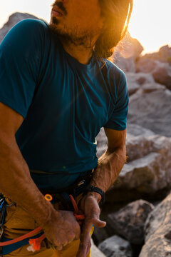 Close up of faceless ethnic mid aged male climber undo rope knot