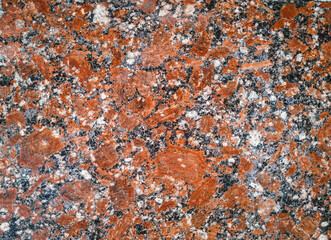Background from red granite natural stone texture. Polished surface, copy space.