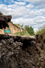 destroyed road consequences of a natural cataclysm of a landslide of soil, crack asphalt paving on...