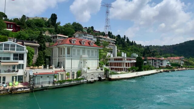 Footage of luxury houses in upscale neighborhood called "Kandilli" by Bosphorus in Istanbul. It is a beautiful summer scene on cloudy summer day. Camera moves forward.