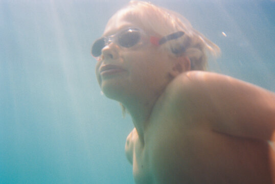boy with googles swimming ocean
