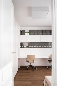 Minimalistic home office in a flat with two chairs and sort folders