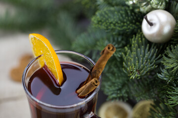 winter treats, a mug of warm wine with an orange, and cookies, ingredients on a wooden brown table. Traditional hot drink for Christmas, in the background Christmas composition