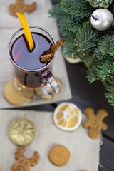 winter treats, a mug of warm wine with an orange, and cookies, ingredients on a wooden brown table. Traditional hot drink for Christmas, in the background Christmas composition