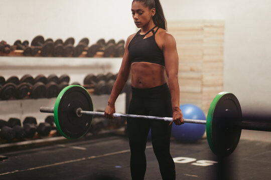 Muscular Young Woman Lifting Heavy Weights In A Gym