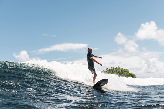 Skilled surfer on foamy wave walking on surfboard