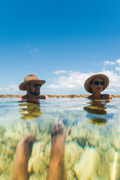 Group of friends joyning sun bath in natural pool in reef