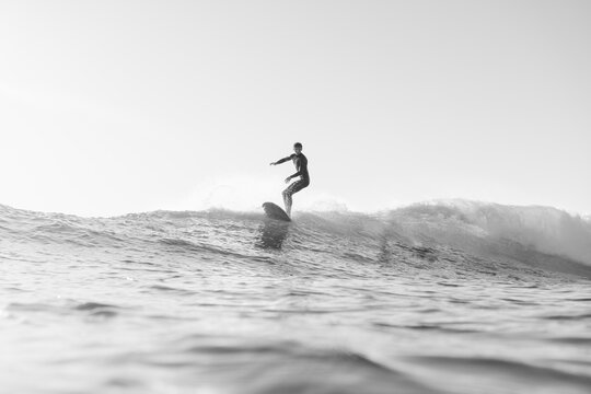 black and white photo of surfer on wave in the ocean