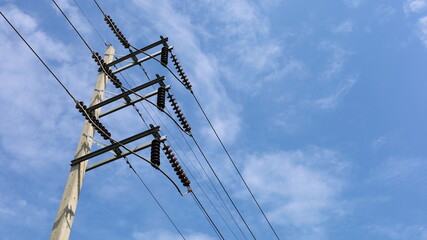 Ceramic insulators with high voltage wires on the poles. Brown insulators on metal beams support...