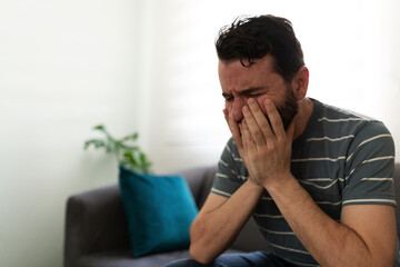 Depressed adult man touching his face