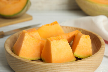 Pieces of tasty melon on wooden plate, closeup