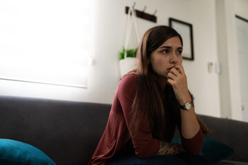 Anxious and stressed woman sitting in the living room