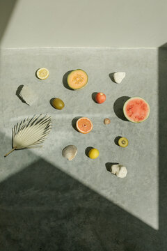 tropical fruits scattered on concrete surface in direct sunlight