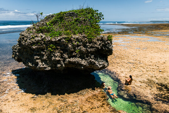 Group of friends joyning sun bath in natural pool in reef