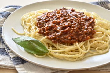 Spaghetti Bolognese with minced beef, onion, chopped tomato, garlic, olive oil, stock cube, tomato puree and Italian herb. Traditional Italian food with a fork.