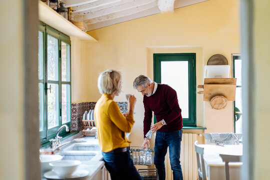 Woman watching husband washing dishes