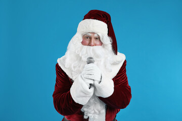 Santa Claus singing with microphone on blue background. Christmas music