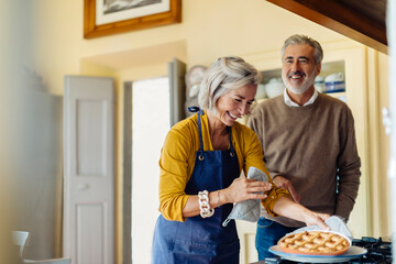 Mature couple laughing at joke in kitchen