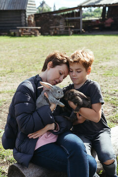 A young mother with her young son with rabbits.
