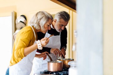 Adult couple examining food while cooking together