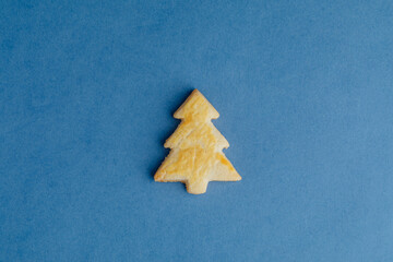 Christmas tree cookie on blue paper background