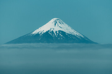 Osorno volcano seen from frutillar lake, surrounded by clouds