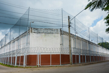 Obraz premium Prison walls with barbed iron wire fence, jail concrete wall against the backdrop of barbed wire