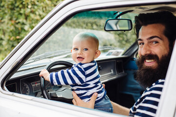 Cheerful father with baby driving car