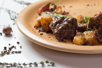 Baked beef cheeks with potatoes