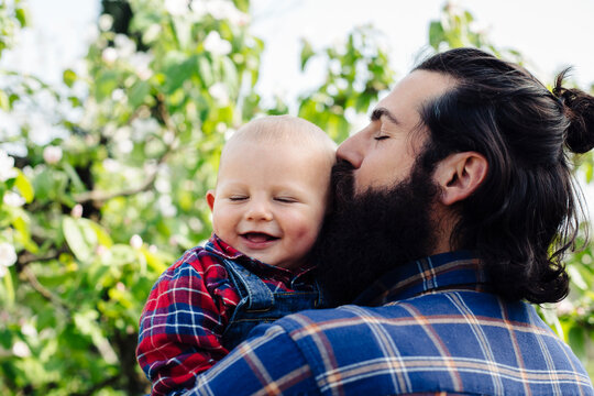 Happy father kissing cheerful baby