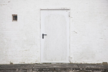 Obraz na płótnie Canvas Painted white door and brick wall 
