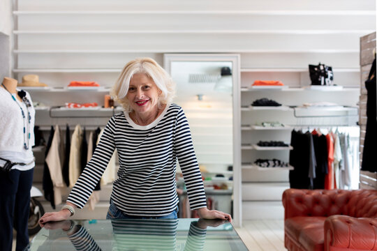 Positive owner of clothing store looking at camera