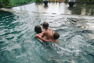 Young boys brothers in a tropical pool.