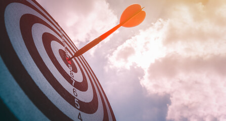 business marketing as concept. Black dart arrow hitting in the target center of dartboard Target...