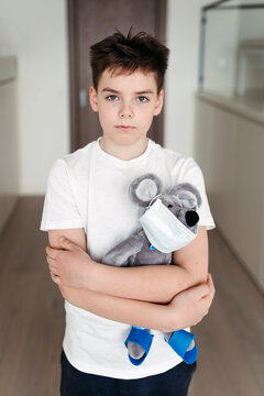 Portrait of a young sad boy with a toy at home.
