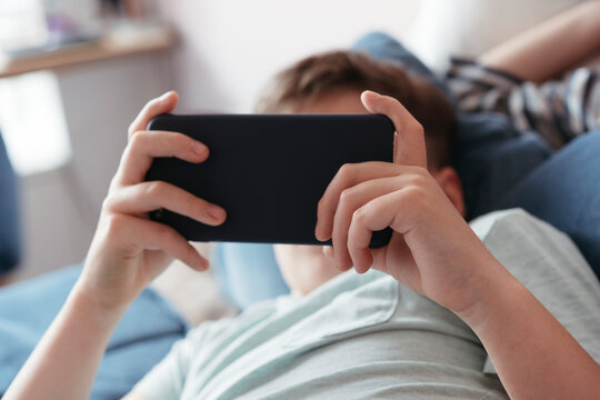 Young brothers use an electronic gadget.