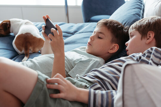 Young brothers use an electronic gadget.