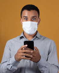 scared man with wearing a mask with a cellphone